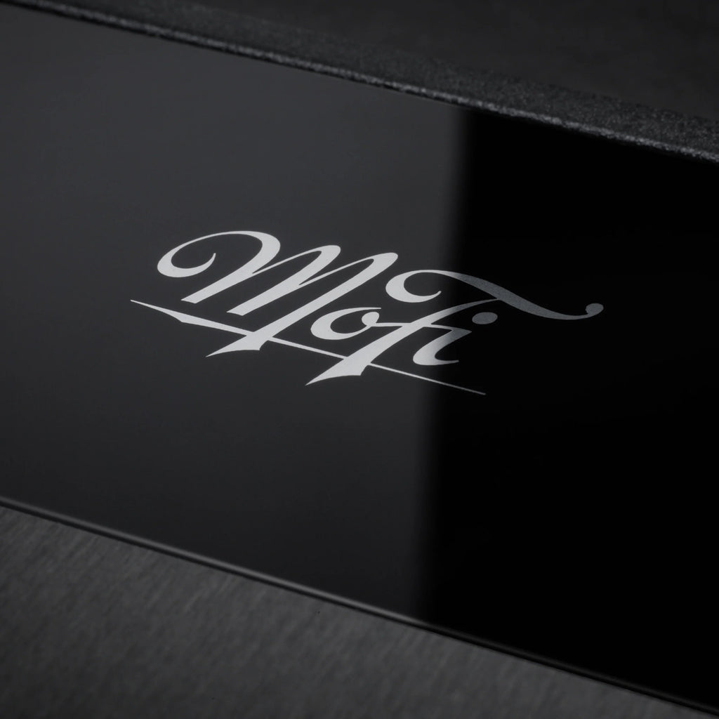 Close-up of MoFi Electronics StudioPhono phono preamp showing input and control knobs on a sleek black device.
