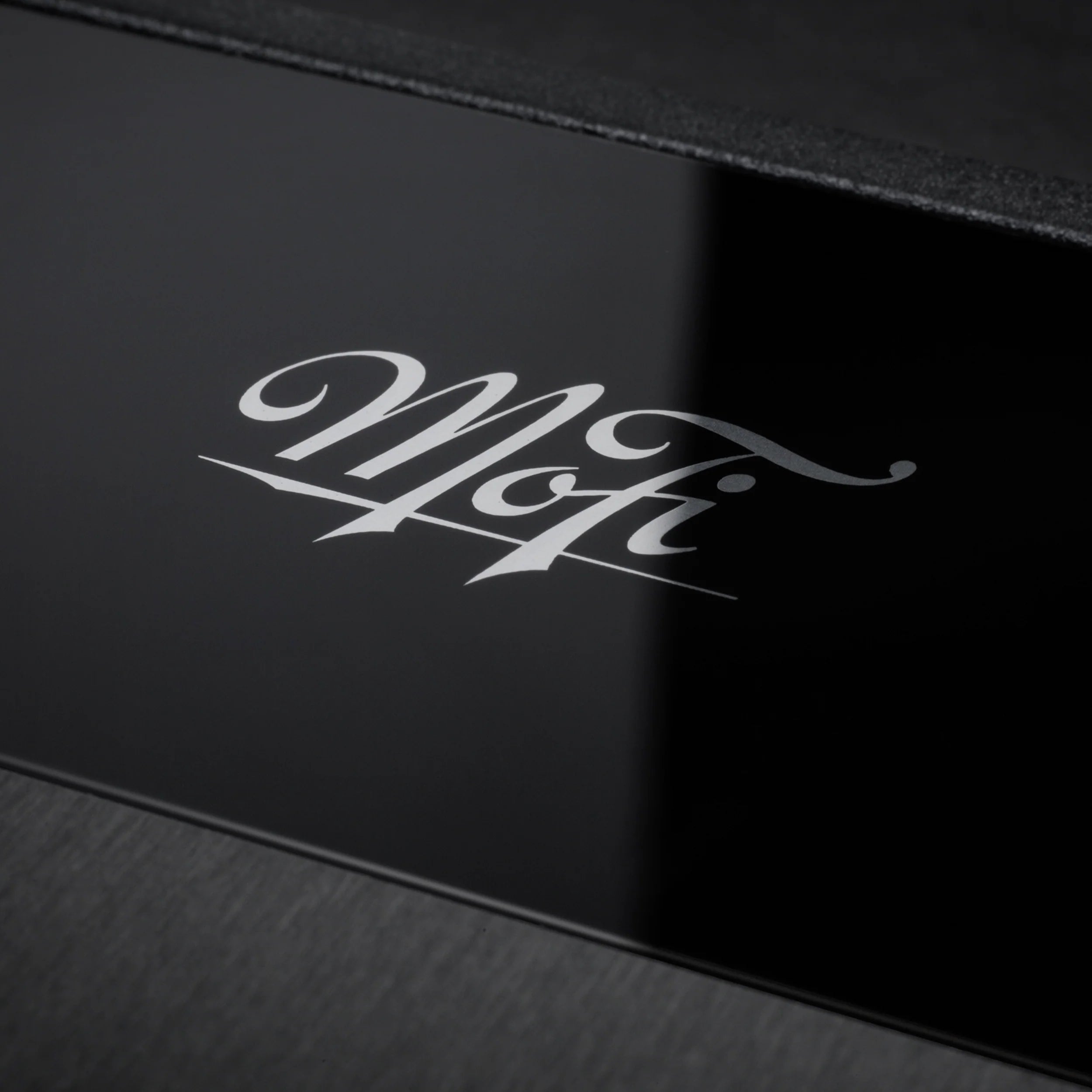 Close-up of MoFi Electronics StudioPhono phono preamp showing input and control knobs on a sleek black device.