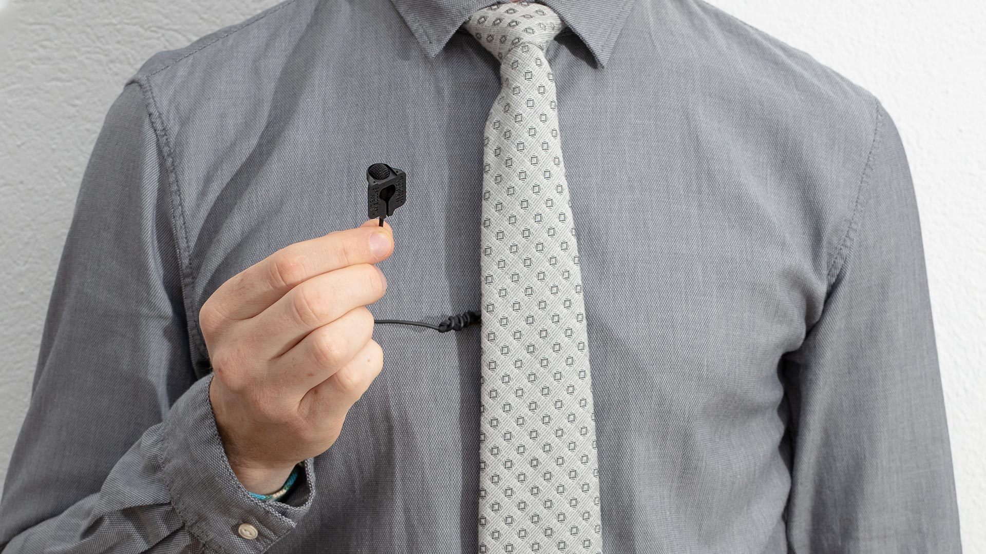 Sennheiser ME 2-II lavalier microphone clipped to a clothing lapel, designed for professional wearable audio recording.