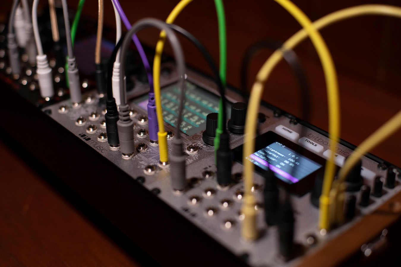 1010music Bitbox Micro semi-modular synthesizer with colorful patch cables and knobs on a music production setup.