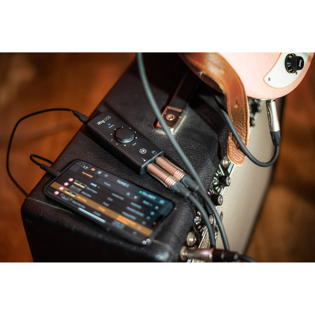 IK Multimedia iRig USB audio interface connected to a computer, showing input and output ports for music and recording purposes.
