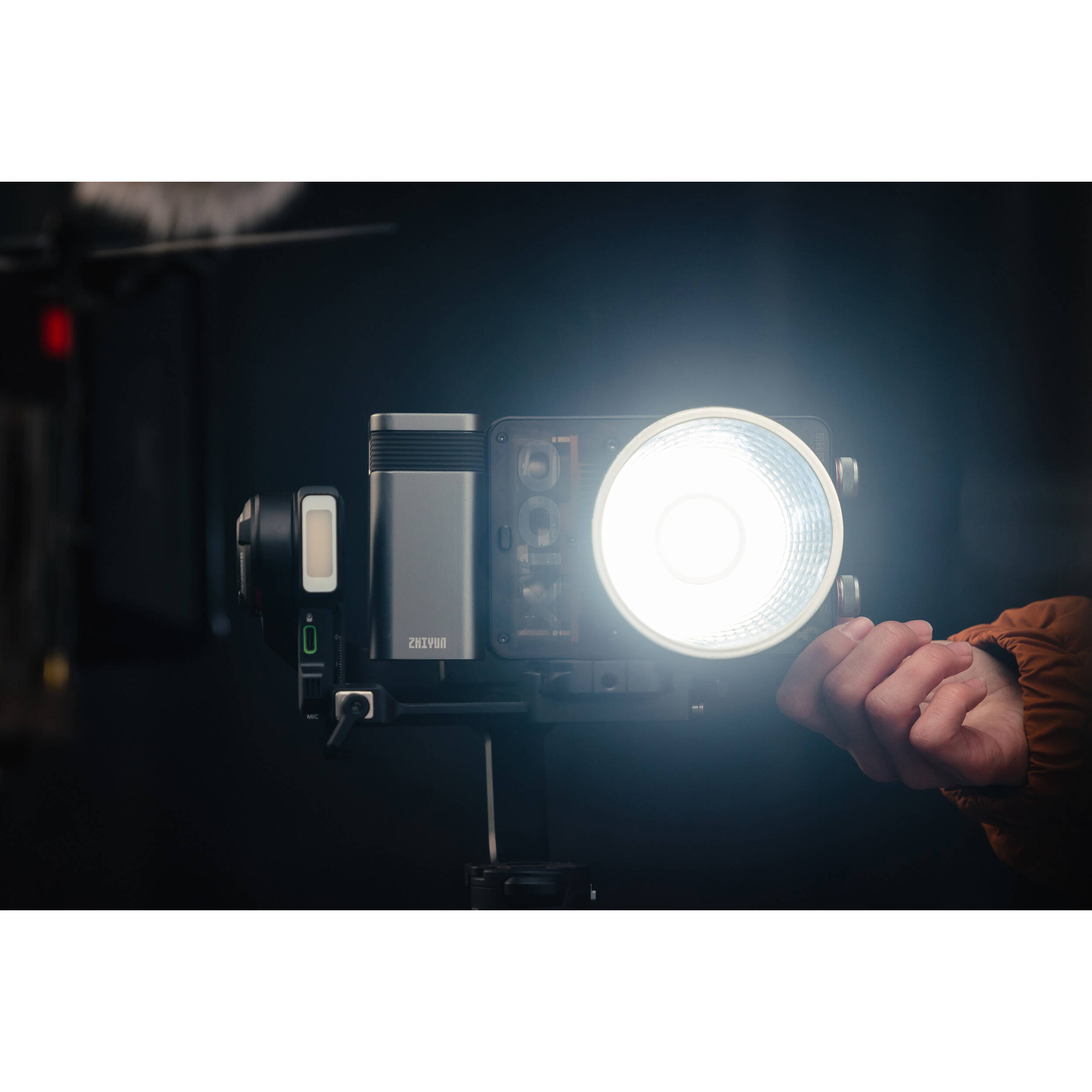 Zhiyun Molus X100 bi-color LED light with adjustable brightness and color temperature, mounted on a stand for professional video lighting.