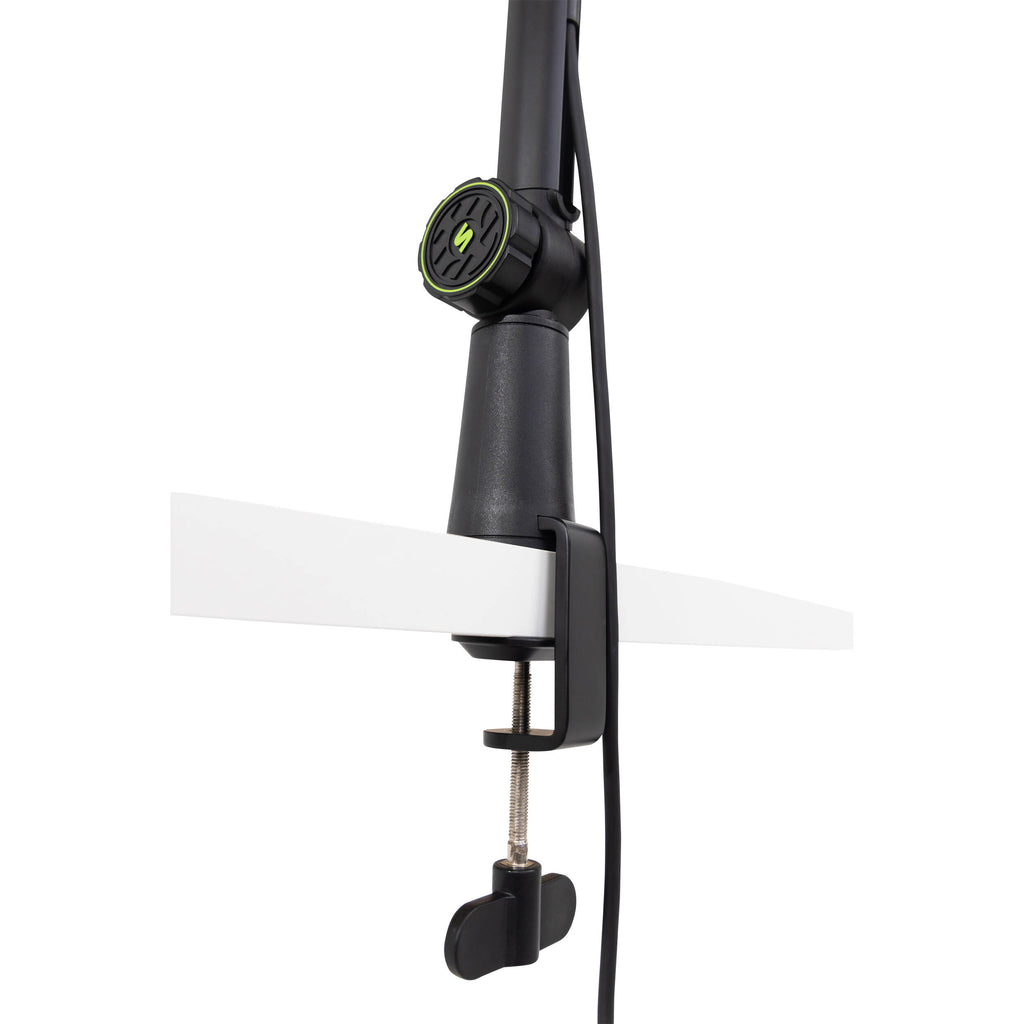 Shure SH-BROADCAST1 broadcast microphone arm mounted on a desk, adjustable metal arm for professional audio setup.