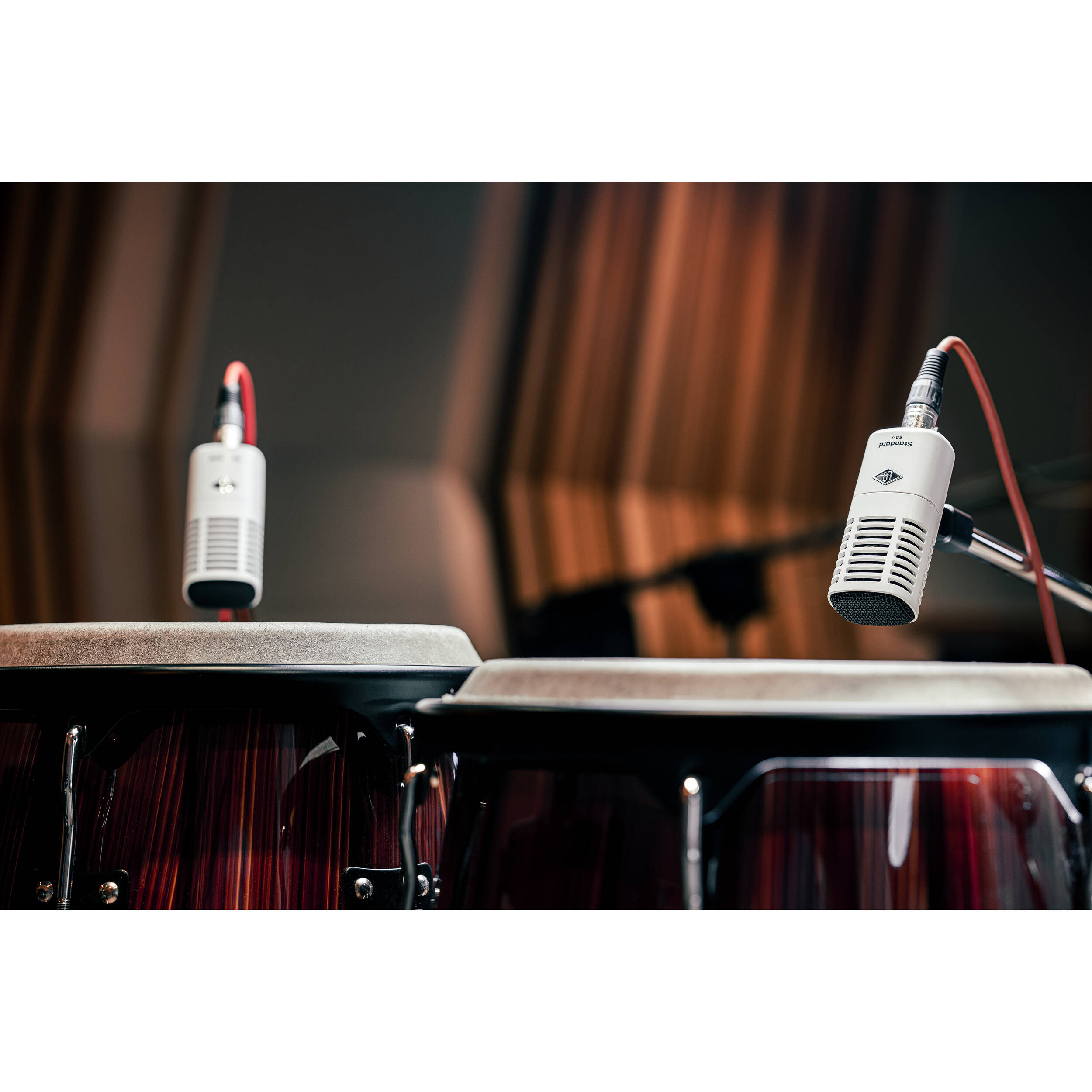 Universal Audio SD-7 dynamic microphone shown with a sleek black design and built-in grille for professional sound recording.