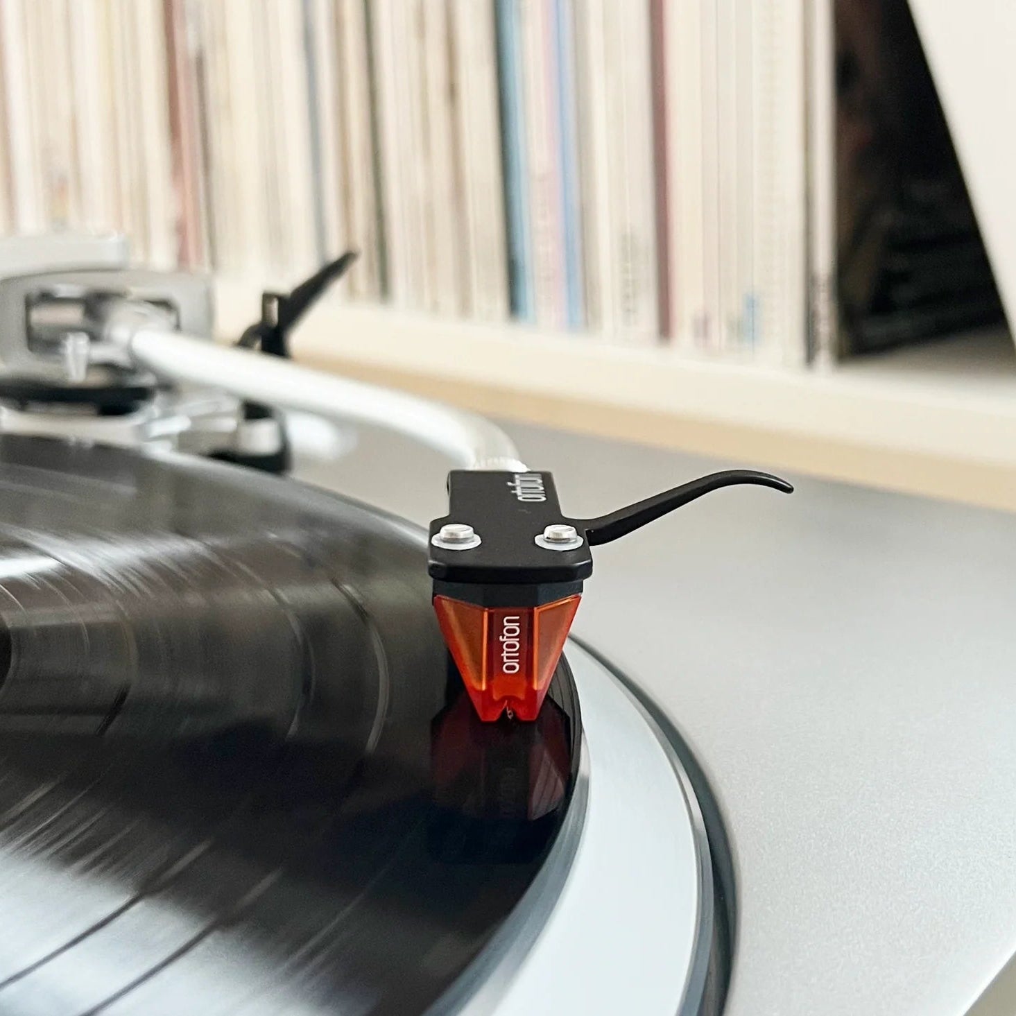 Ortofon 2M Bronze turntable cartridge with stylus, detailed close-up showing its metallic body and stylus tip for high-quality audio.
