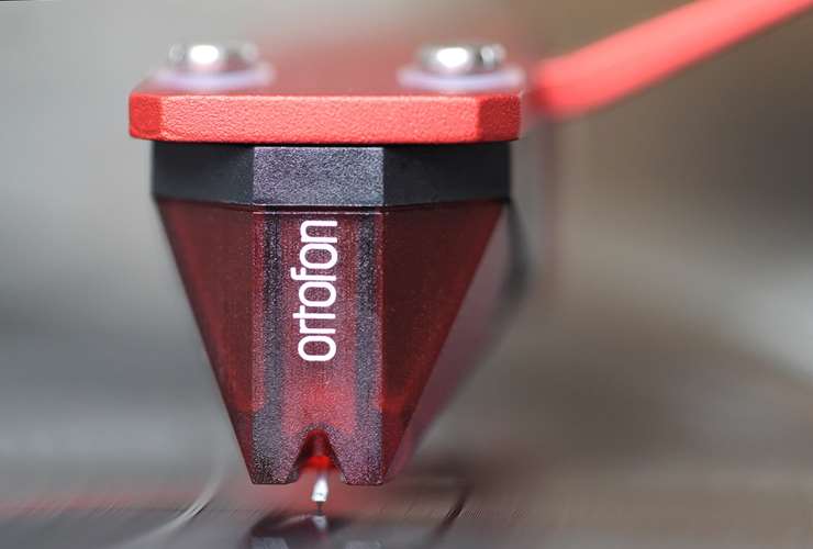 Ortofon 2M Red Verso turntable cartridge mounted on a record player, showcasing its sleek design and stylus.