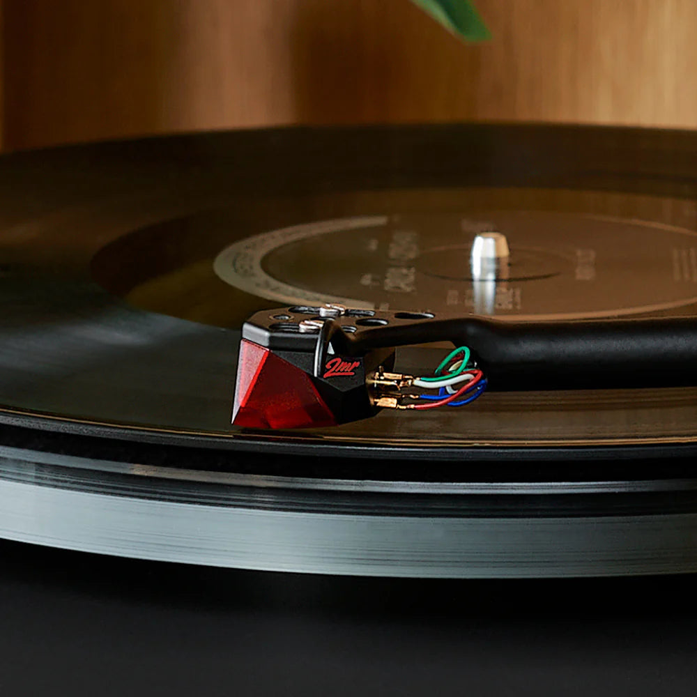Close-up of Ortofon 2MR Red turntable cartridge showing its red body and stylus tip for high-quality vinyl playback.