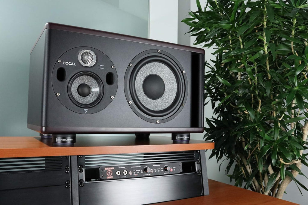 IsoAcoustics ISO-Puck 76 studio monitor stand isolators on a surface, designed to improve audio clarity and reduce vibrations.
