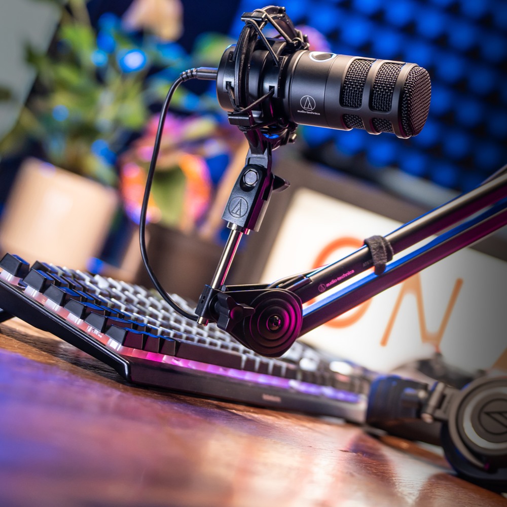 Audio Technica AT2040USB USB microphone on a podcasting setup with a pop filter and audio interface in a studio environment
