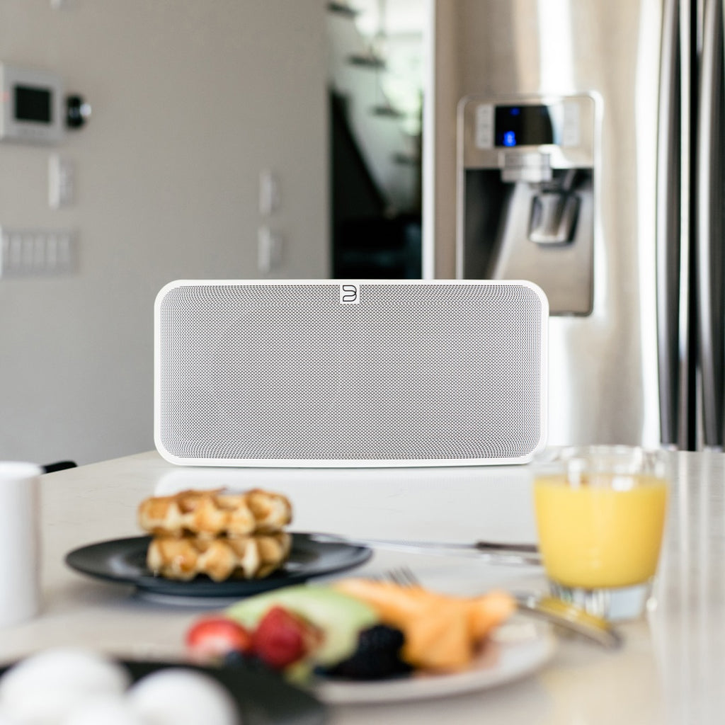 Close-up of Bluesound Pulse 2i wireless speaker in white, showing its sleek front design and control buttons.