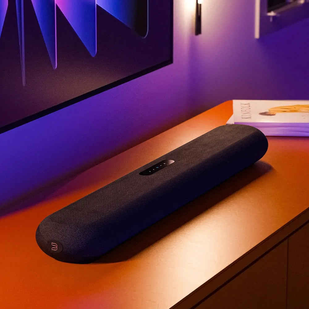 Bluesound Pulse Cinema Mini soundbar with sleek design and modern TV setup, delivering immersive audio for home entertainment.