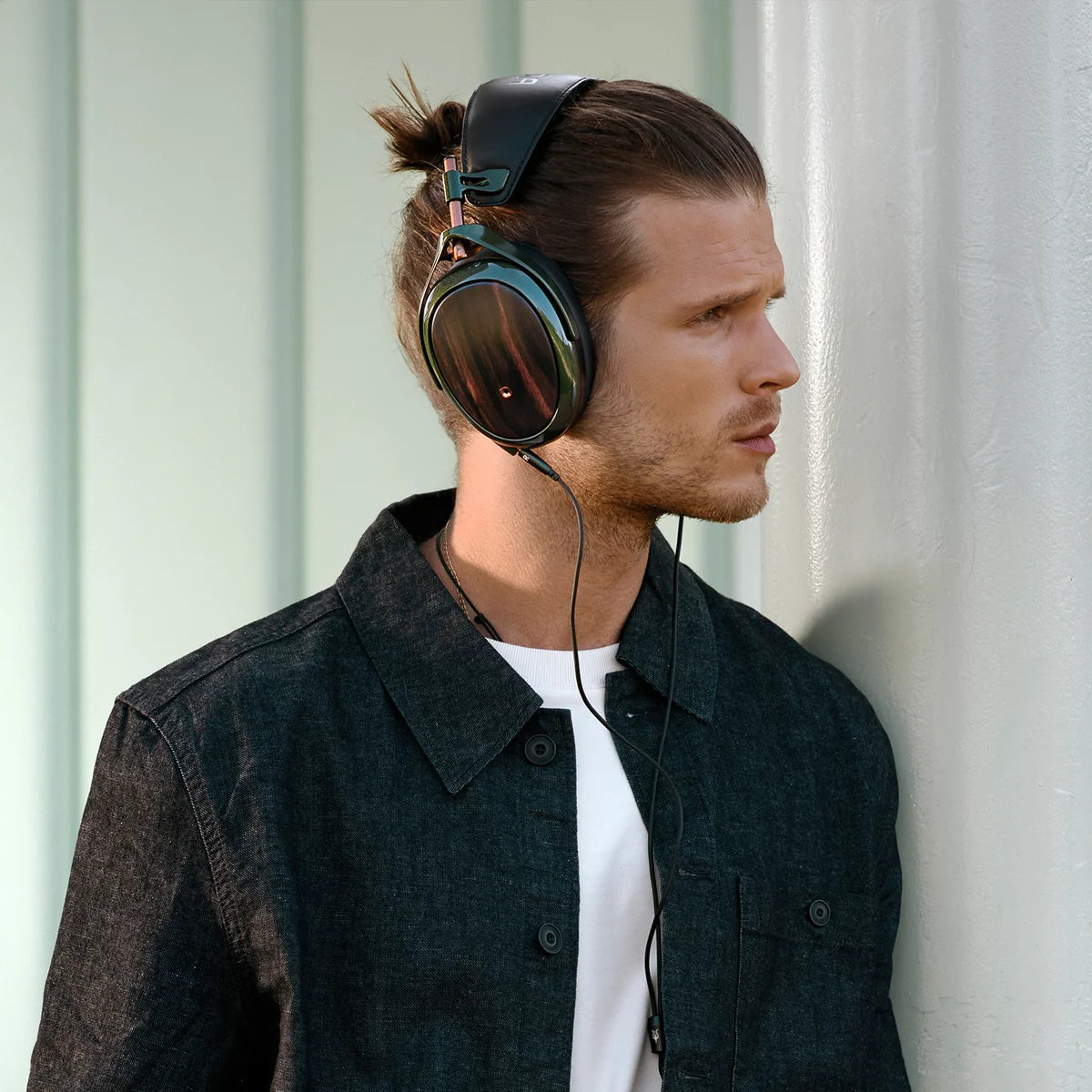 Meze Audio Strada wired headphones with sleek black design and padded ear cups, shown from a side angle.