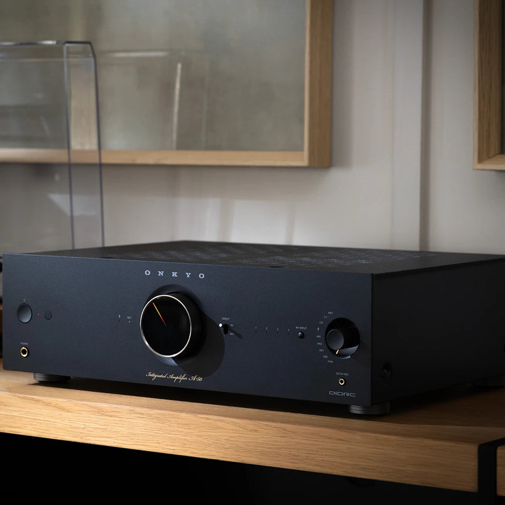Onkyo Icon A-50 stereo amplifier in black beside a turntable in a stylish listening room setting.