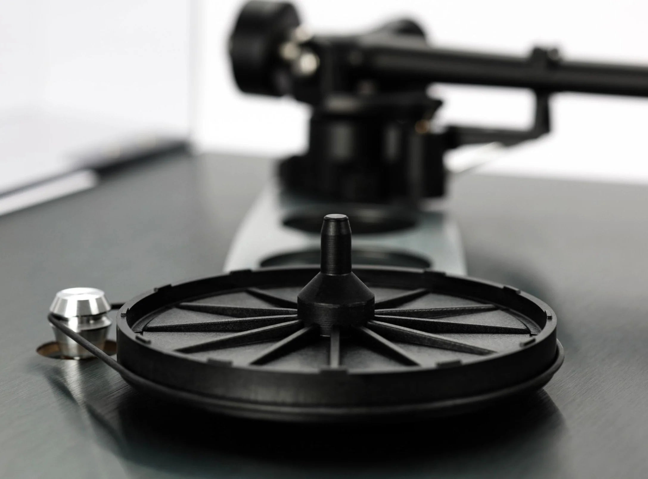 Close-up of Rega Planar 3 RS turntable with aluminum platter and Nd5 cartridge, showing the hub bearing and tonearm details.