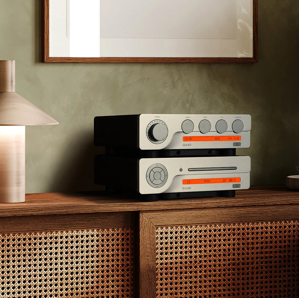 Quad 3CDT CD player sitting on a modern media stand, featuring a sleek black design and multiple disc trays, for high-quality audio playback.