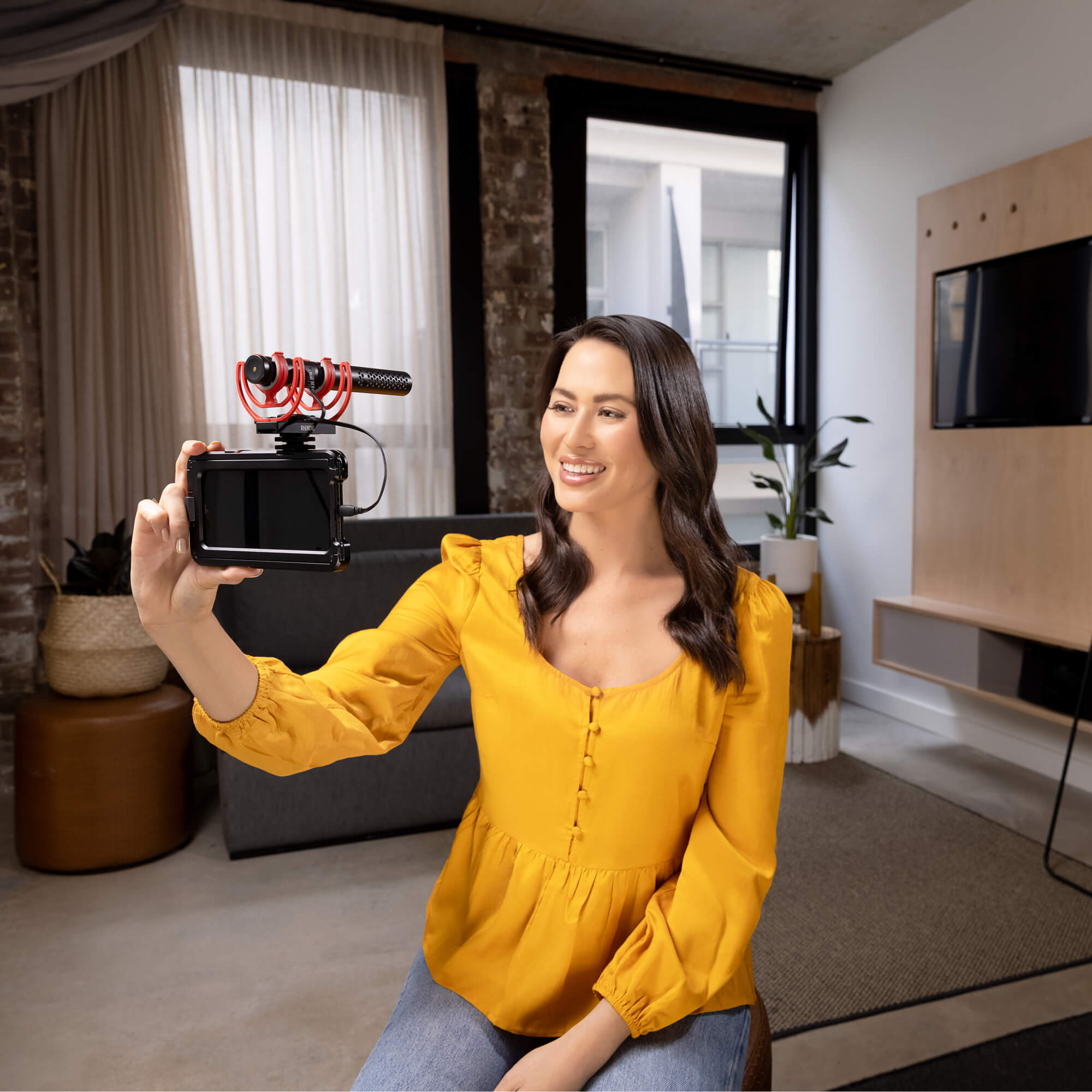 Rode SC15 USB C cable with video microphone, shown in a scene with a girl using a smartphone indoors.