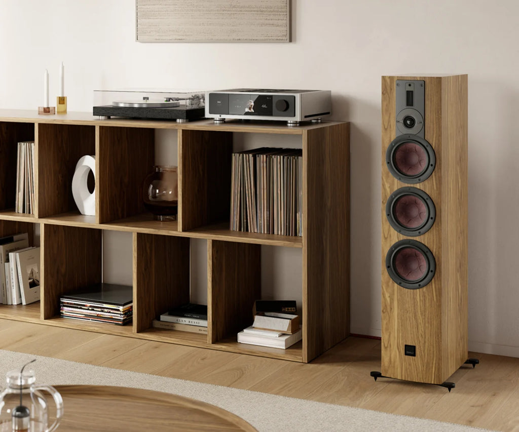 DALI Rubikore 8 passive floorstanding speakers in a living room setting, showcasing sleek black design and modern audio equipment.