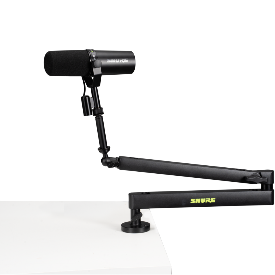 Shure SH-BROADCAST2 broadcast microphone arm mounted on a desk with adjustable joints and cable management system.