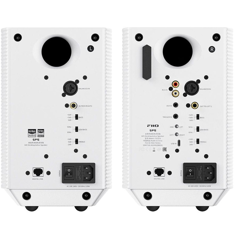 FiiO SP5 desktop speakers with black finish, compact design, and control knobs on the front panel, placed on a wooden surface