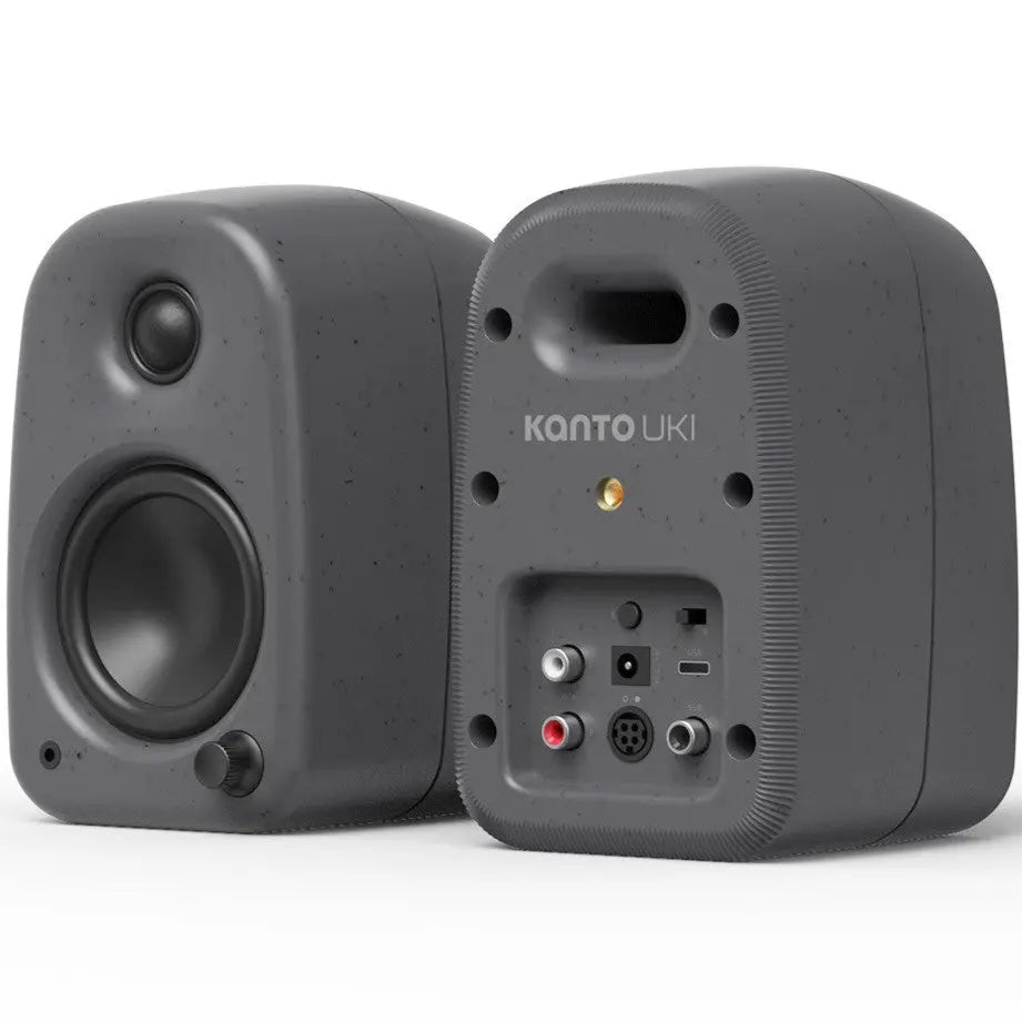 Kanto Audio UKI desktop speakers with sleek black design, featuring dual speaker units and control knobs on a modern workspace.