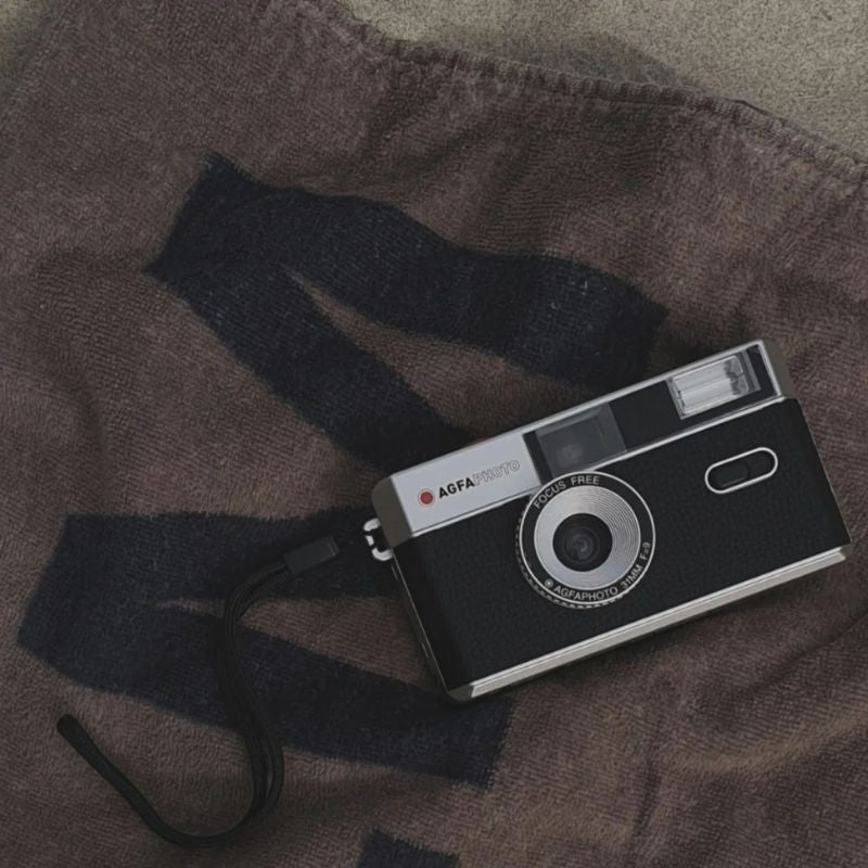 AgfaPhoto reusable compact camera, vintage style, with black body and silver accents, designed for instant film photography