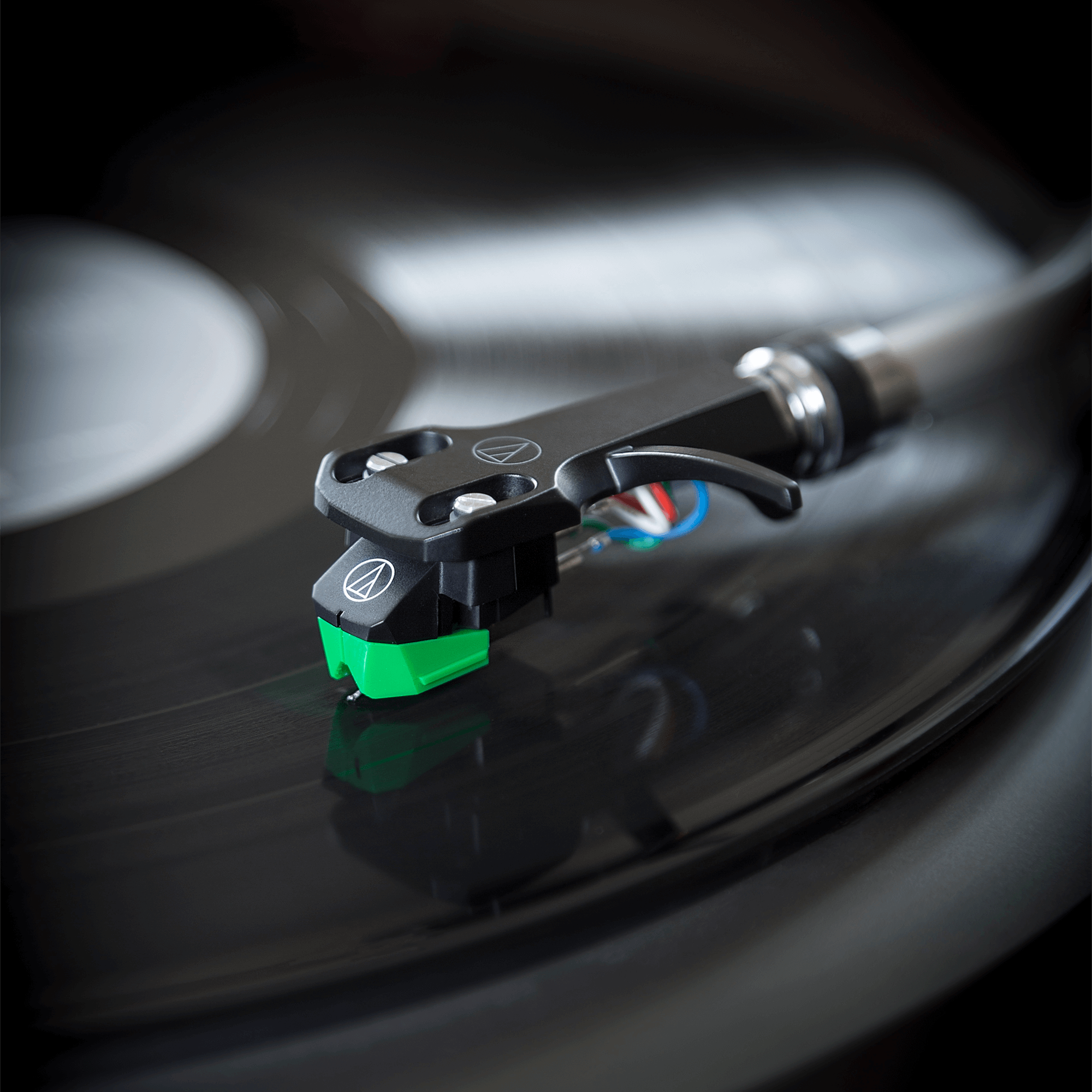 Audio Technica AT-VM95E/H turntable cartridge with headshell, featuring detailed stylus and mounting hardware for record players.