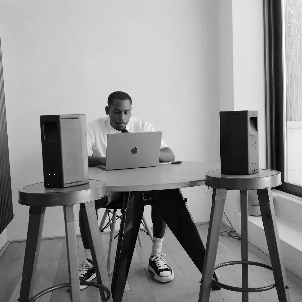 AIAIAI UNIT-4 Wireless+ active nearfield monitors shown with sleek black finish and front speaker grille on a studio desk.