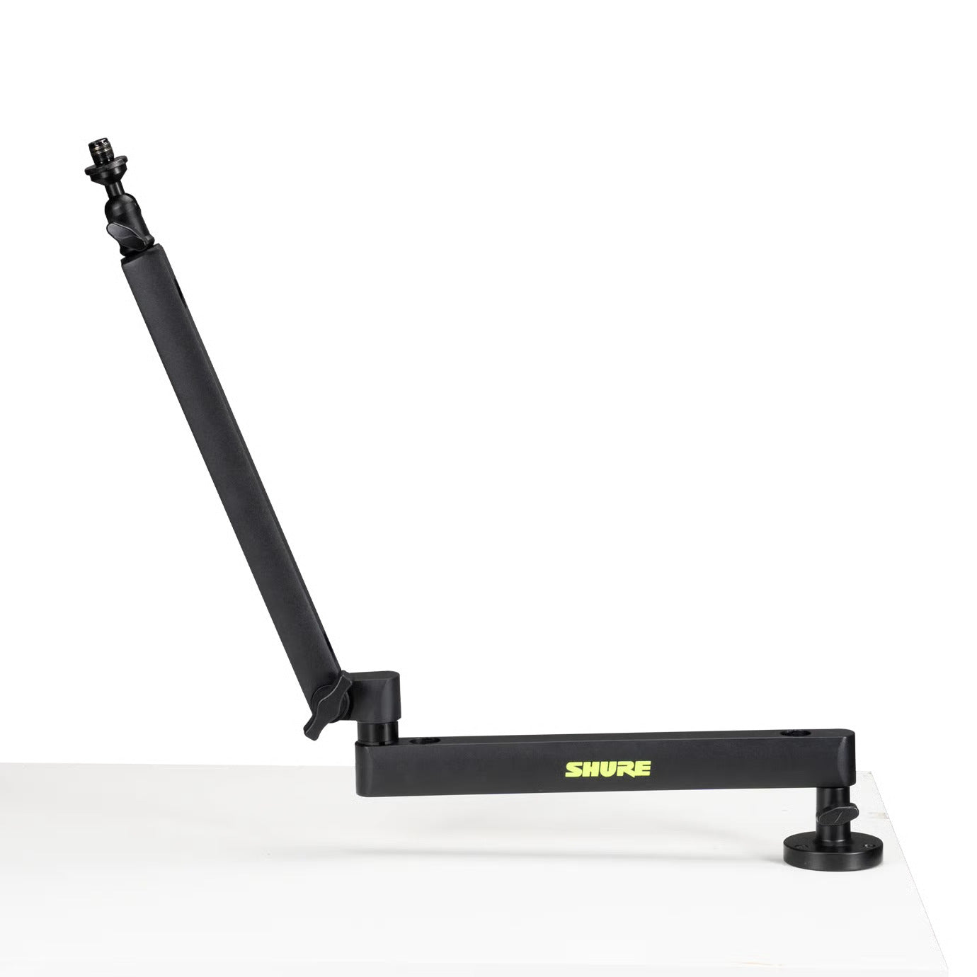 Shure SH-BROADCAST2 broadcast microphone arm mounted on a desk, adjustable boom arm for professional audio recording setups.