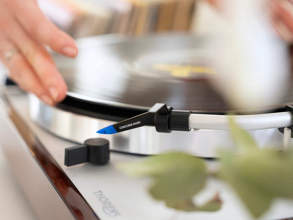 Ortofon Concorde Music Blue turntable cartridge mounted on Thorens turntable, showcasing sleek blue stylus and cartridge body.