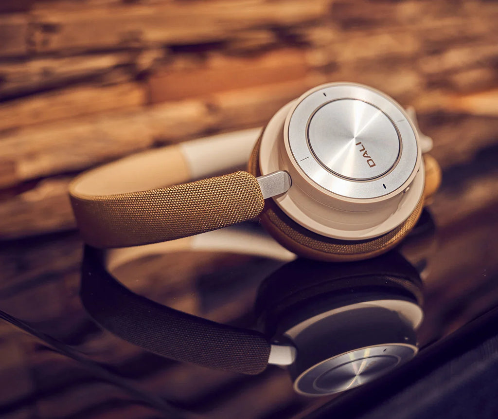 Close-up of DALI Dali iO-8 wireless headphones reflecting light, showcasing sleek design and premium build quality.