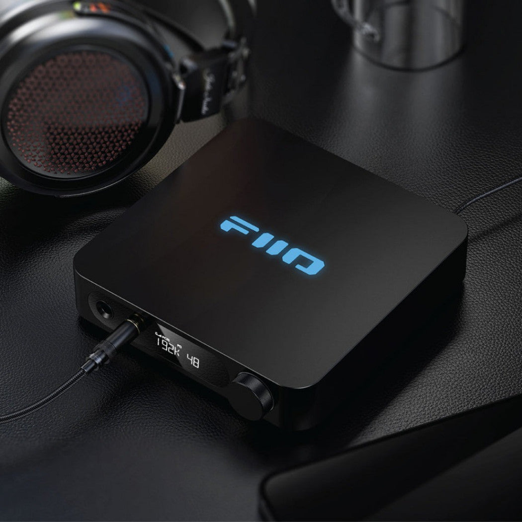 FiiO K11 headphone amplifier and DAC, in black, lifestyle setting