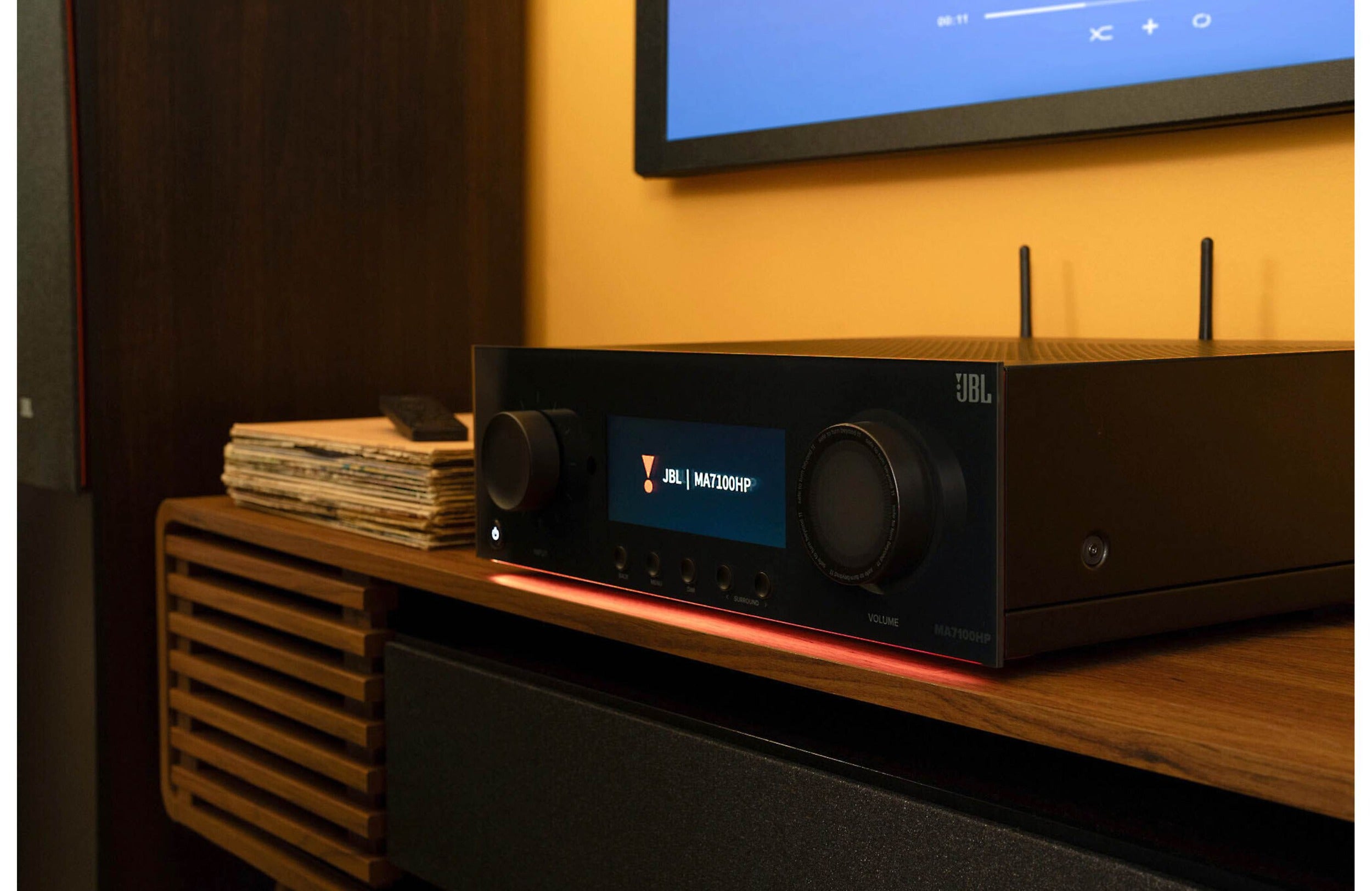 JBL MA7100HP stereo amplifier with black front panel, multiple control knobs, and input/output ports for high-quality audio.