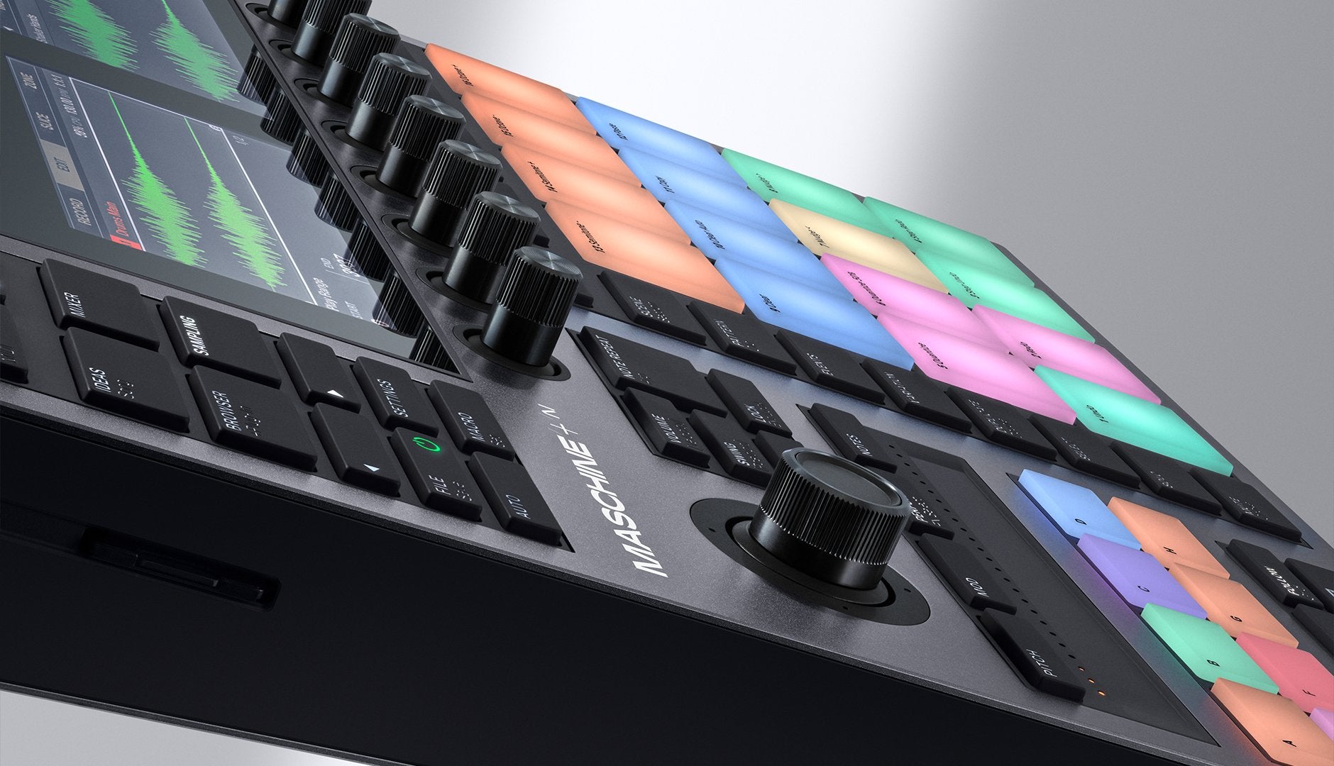 Native Instruments Maschine+ drum machine and sampler with colorful pad interface and control knobs on a sleek black device.