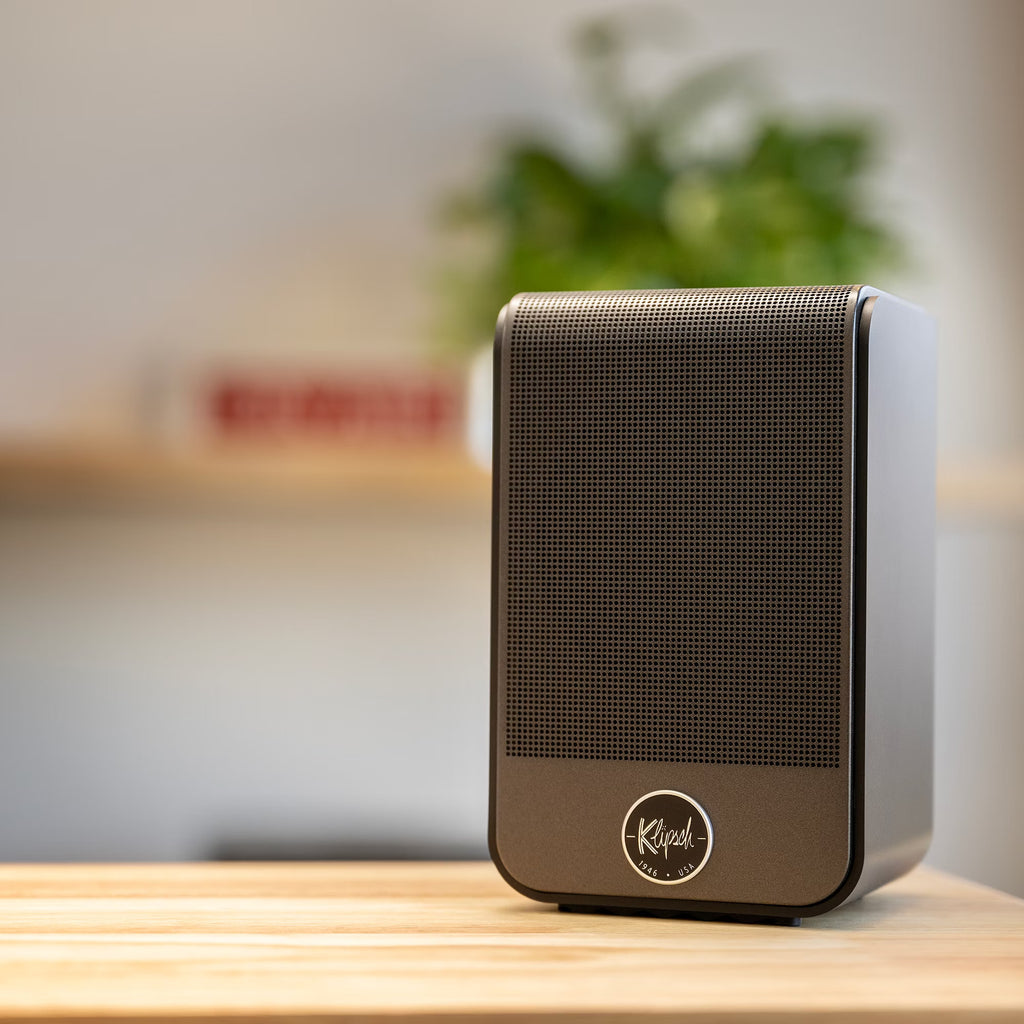 Klipsch Flexus SURR 100 soundbar on a table, showcasing its sleek black design and compact TV speaker setup.