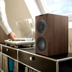 KEF Q1 Meta passive bookshelf speakers shown with sleek black cabinets and detailed drivers for high-quality audio.