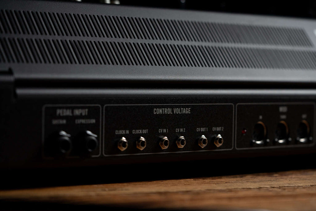 Moog Muse synthesizer with black background, showcasing its knobs and interface in a close-up shot.
