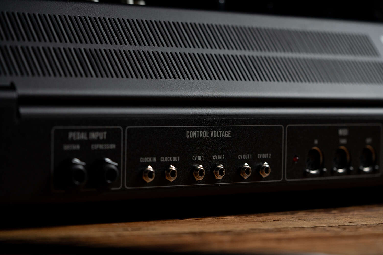 Moog Muse synthesizer with black background, showcasing its knobs and interface in a close-up shot.