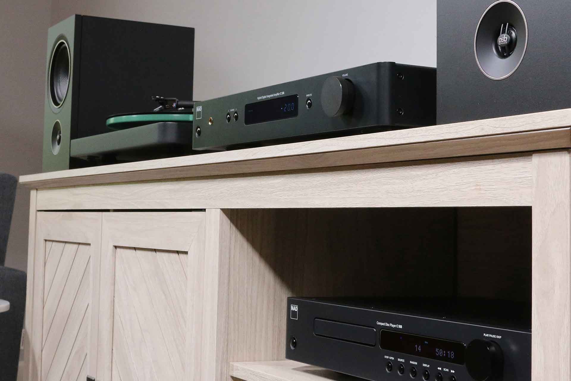 NAD C 338 stereo amplifier installed with front panel controls and connections visible in a home audio setup.