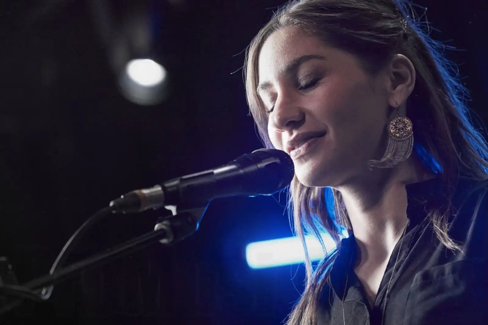 Shure Nexadyne 8/S dynamic microphone on a stage setup, ready for live performance with professional audio equipment.