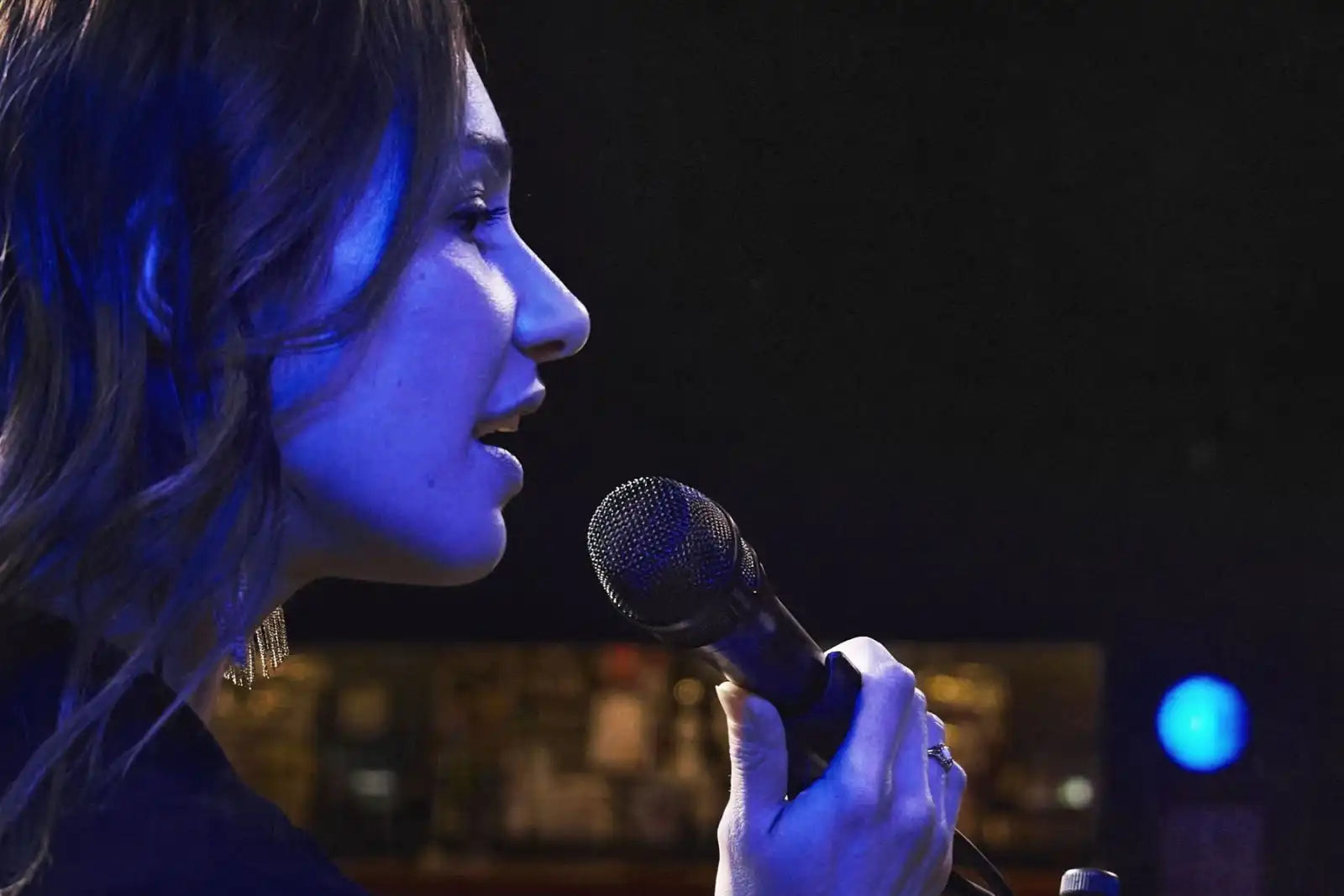 Shure Nexadyne 8/S dynamic microphone on stage, ready for live performance, with a professional audio setup.