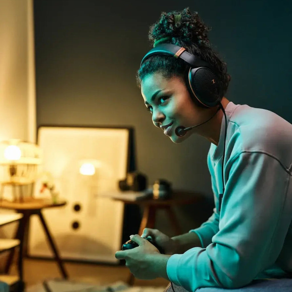 Woman gaming with Sennheiser headphones and the HD 500 BAM boom microphone