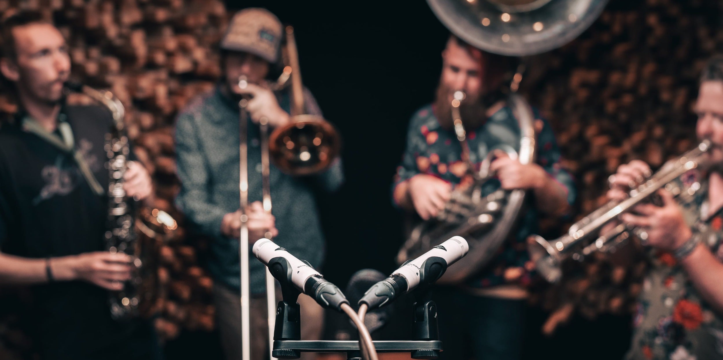 Universal Audio SP-1 condenser microphone with sleek black body and gold accents, showing the detailed front view and microphone grille.